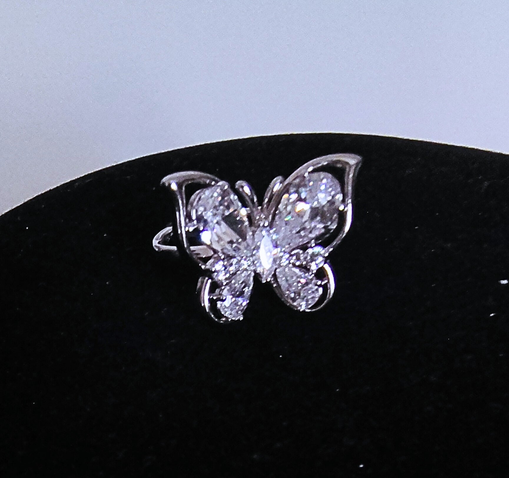 Silver with clear gems butterfly ring on a black stand