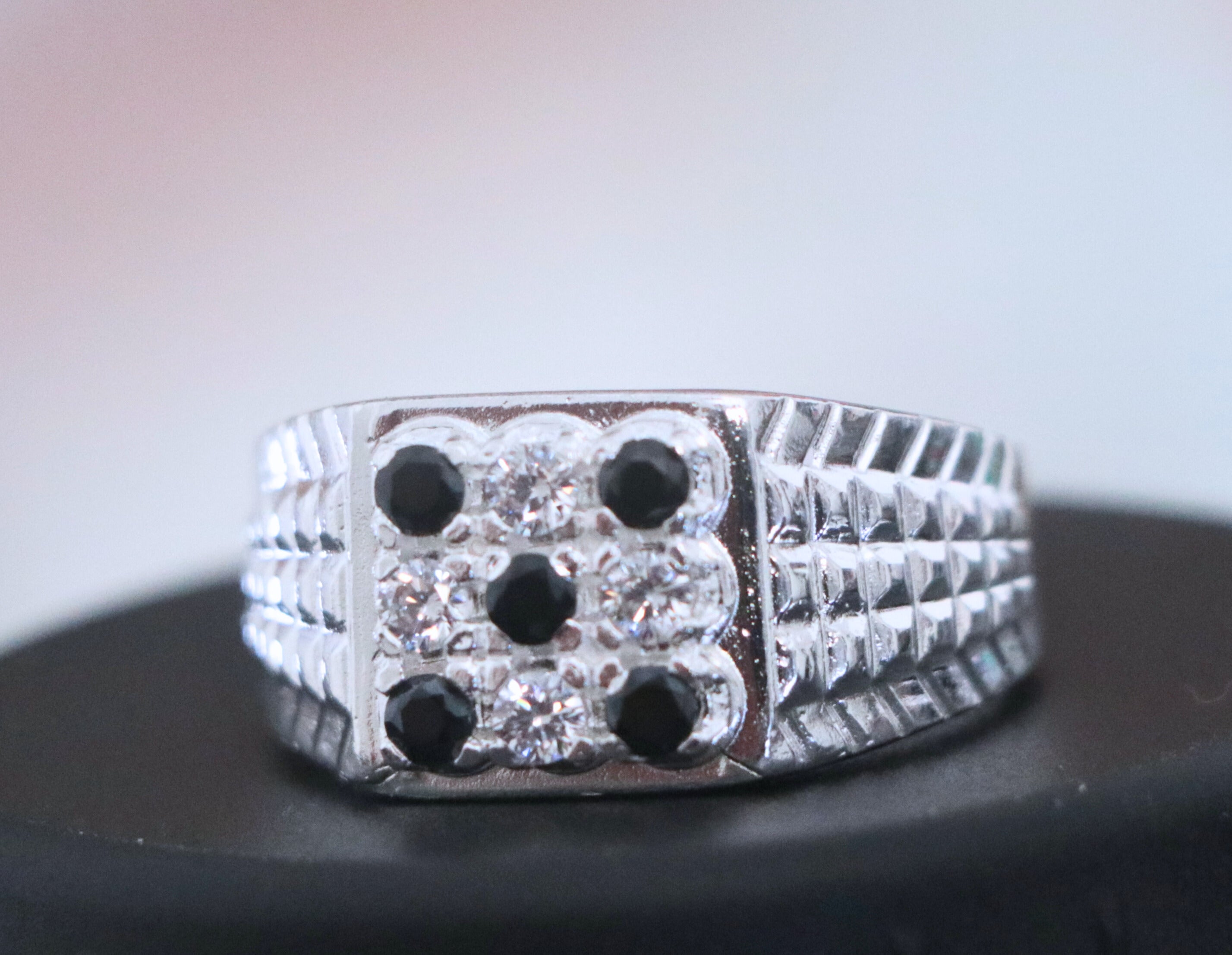 Silver ring with black stones on a dark surface