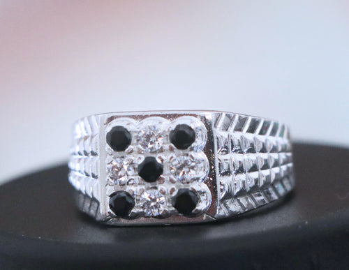 Silver ring with black stones on a dark surface